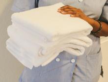 Housekeeping staff with a stack of clean white towels