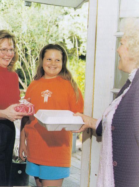 Volunteer Terri Becker (and her daughter Sara), who is now employed by Eskaton, is shown delivering a holiday gift to a TLC client in 1997.